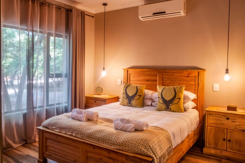 Image showing the main bedroom which is has a large double bed with air condition above the bed. Room is safari themed